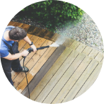 Man pressure washing deck