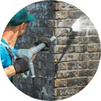man pressure washing house