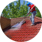 man pressure washing roof